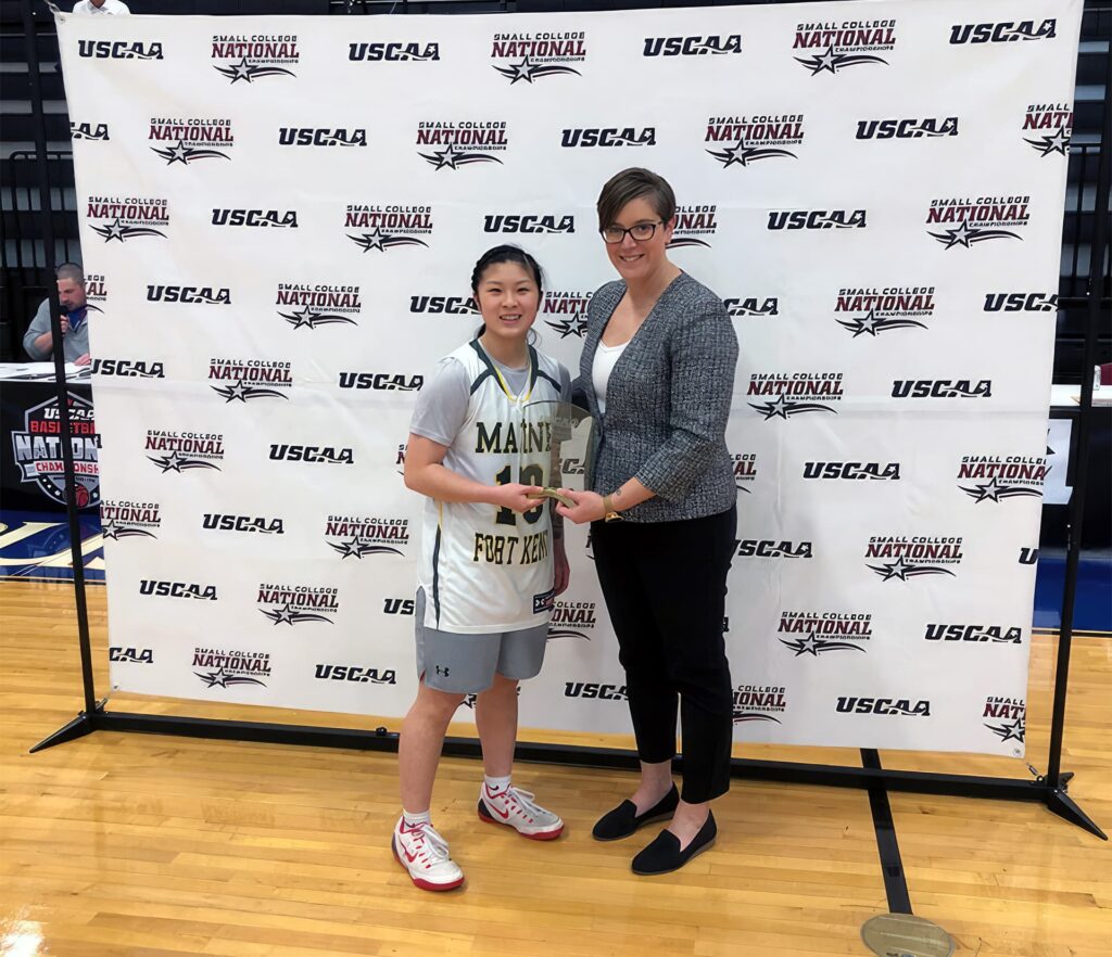 Keri La, winner of the USCAA National Tournament Skills Challenge 3-point contest, with a representative from the USCAA.