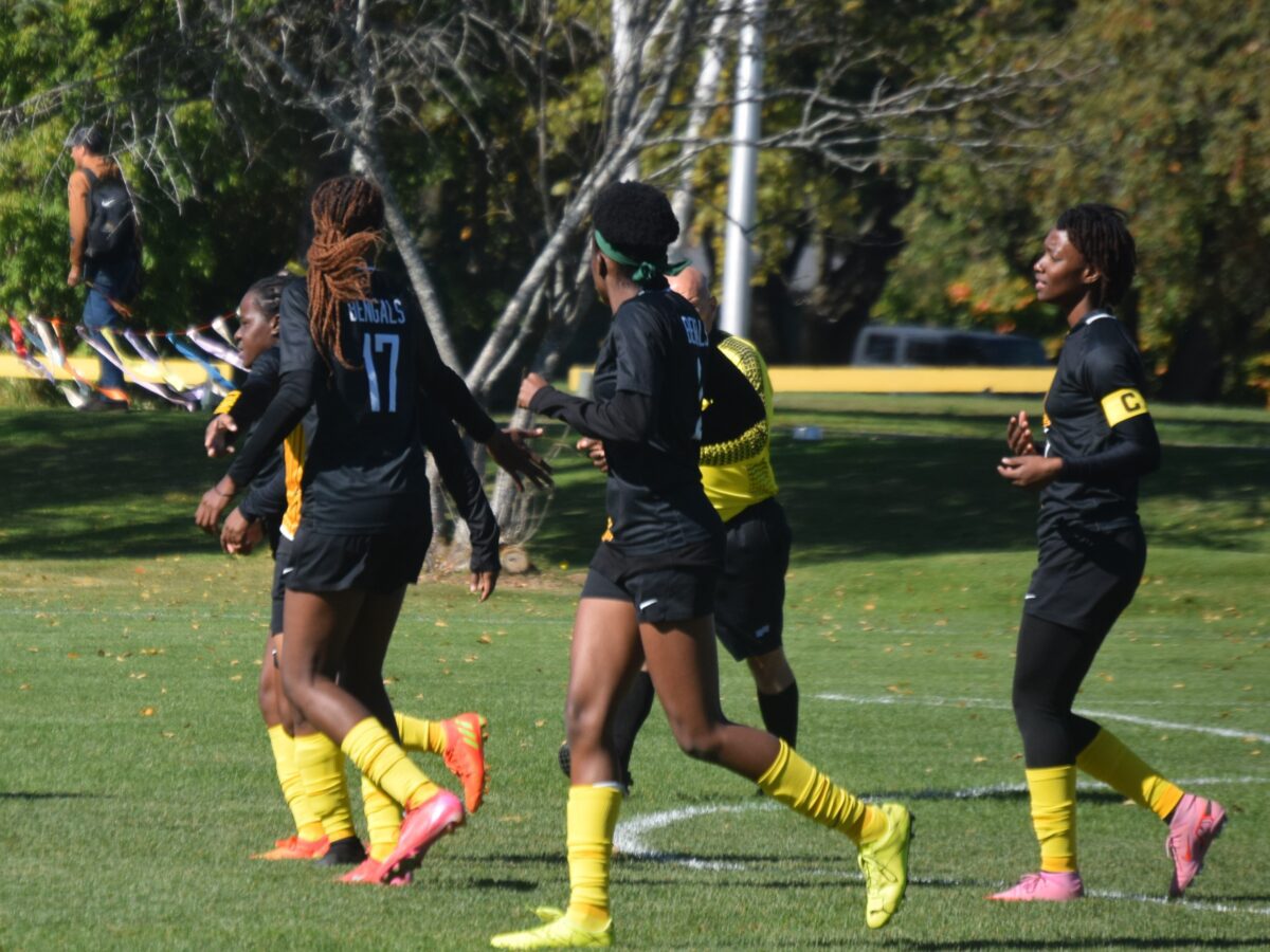 a group of women's soccer players jog down the field together