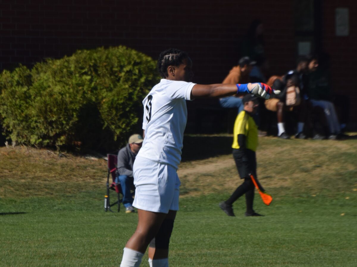 a women's soccer player gestures to one of her teammates