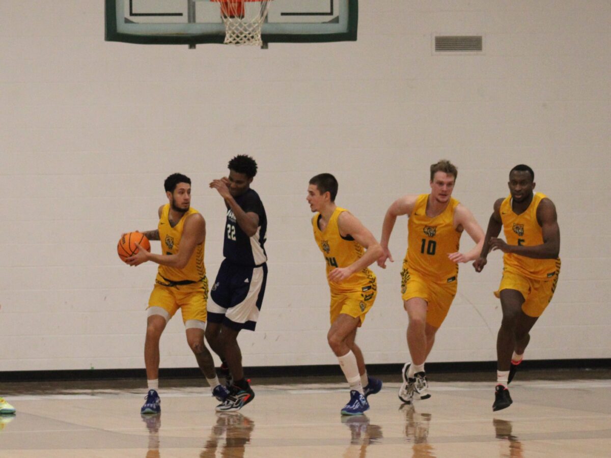 a men's basketball player defends the ball against the opponent guarding him