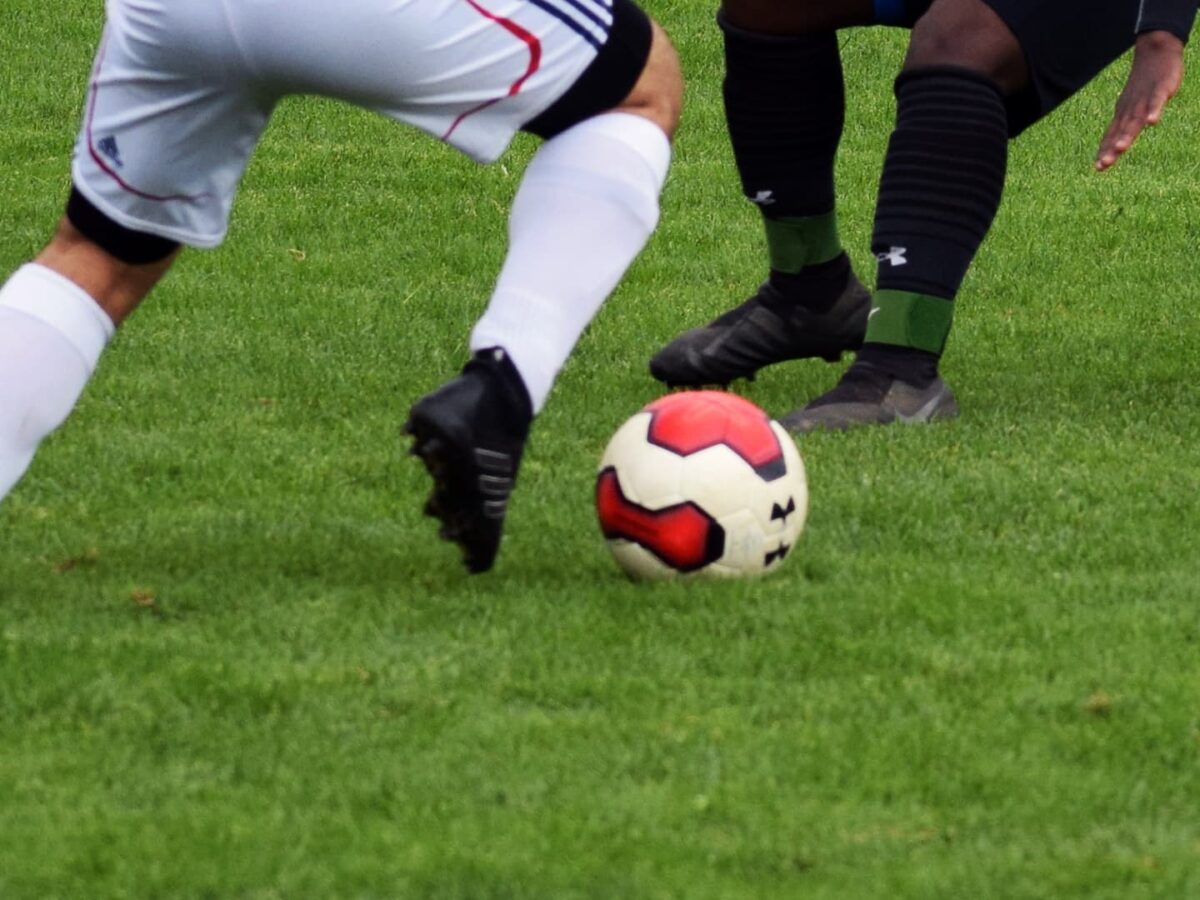 two soccer players vying for the soccer ball