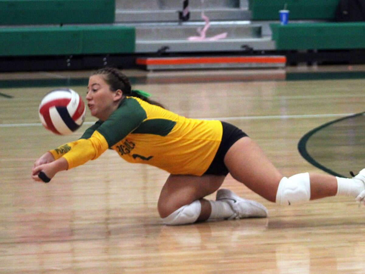 a UMFK women's volleyball player dives to the floor to keep the ball in play